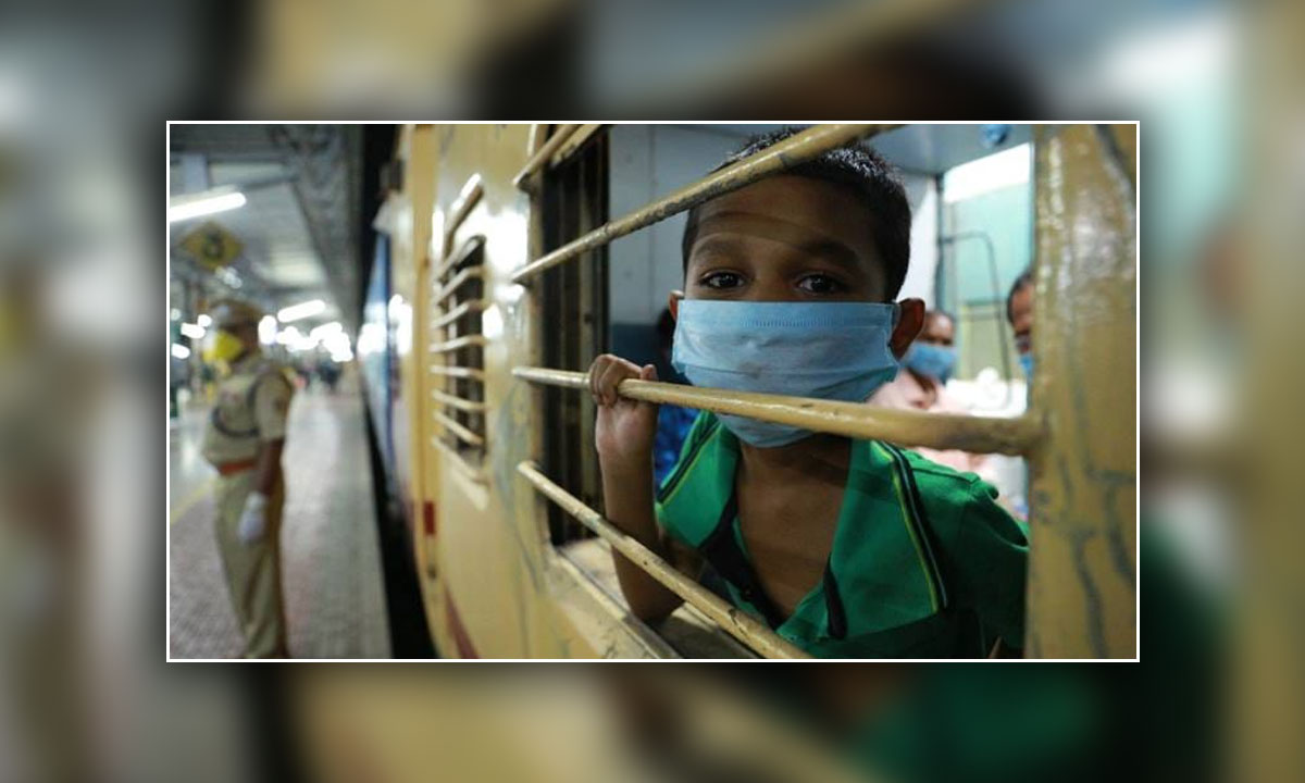 A child looks from the window of a special train run for migrants from Kerala to Jharkhand.