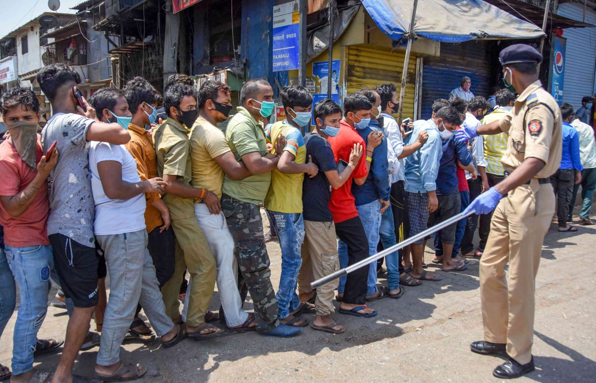 Migrant workers in Mumbai's Dharavi wait in queue. Credit: PTI