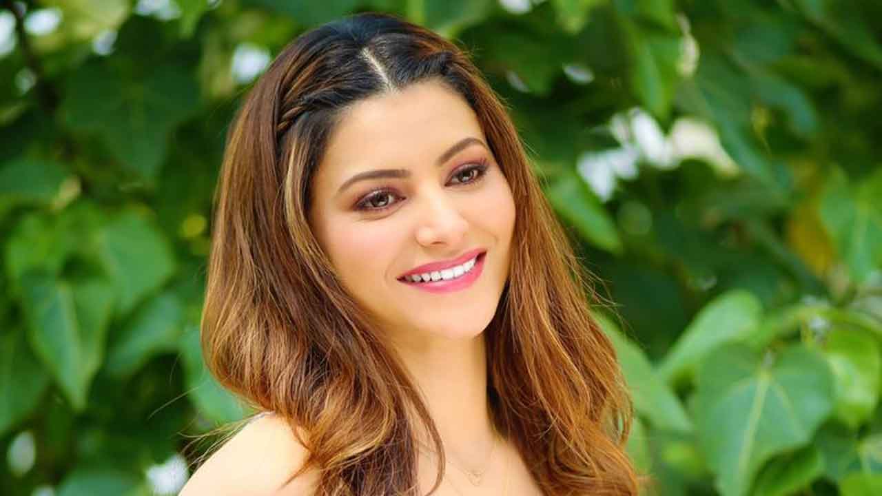 Urvashi Rautela distributes Tirumala Prasad to photographers at the airport